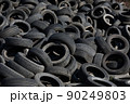 Landfill with old tires and tyres for recycling. Reuse of the waste rubber tyres. Disposal of waste tires. Worn out wheels for recycling. Regenerated tire rubber produced. 90249803