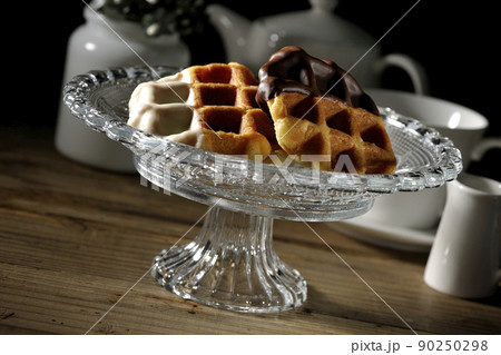 ケーキスタンドに盛り付けられているチョコがコーティングされたワッフルとティーセット 90250298