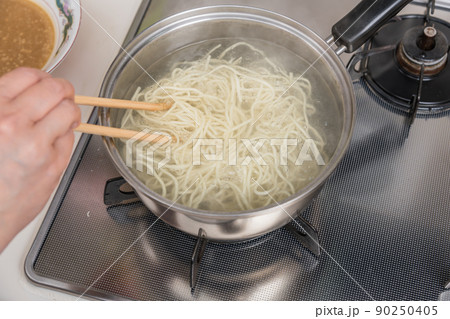 【ミドル主婦がラーメンの麺を菜箸を使って茹でる】 90250405