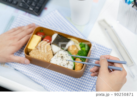 SDGs オフィスでマイ箸を使ってお弁当を食べるビジネスマンの手元のアップ 90250871