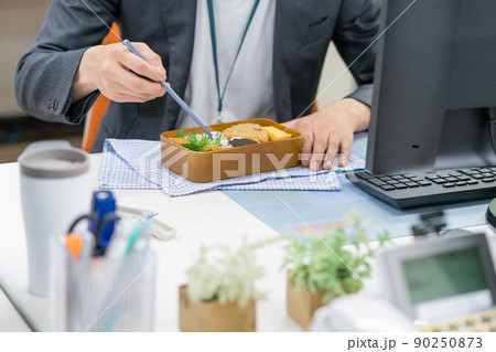 SDGs オフィスでマイ箸を使ってお弁当を食べるビジネスマンの手元のアップ 90250873