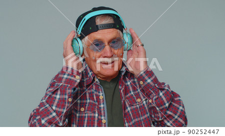 Cheerful attractive man listening music via headphones and dancing disco fooling around having fun Cheerful attractive man listening music via headphones and dancing disco fooling around having fun 90252447