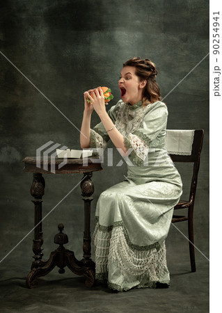 Comic portrait of young beautiful girl in gray dress of medieval style isolated on dark background. Comparison of eras concept, flemish style. Art, beauty 90254941