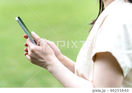 緑豊かな公園でスマホを使う女性【パーツカット】 緑豊かな公園でスマホを使う女性【パーツカット】 90255640