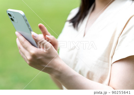 緑豊かな公園でスマホを使う女性【パーツカット】 90255641
