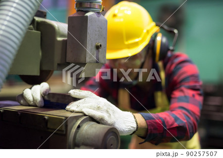 Factory worker place piece of iron to drill by old manual machine 90257507