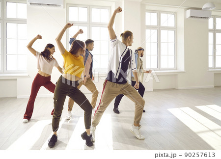 Active young people dancing together in studio 90257613