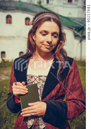 Portrait of brunette woman dressed in historical Baroque clothes with old fashion hairstyle, outdoors. 90257681