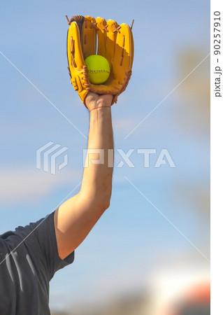 A Vertical view of a baseball player holding a glove and a ball.  90257910