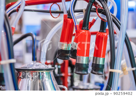 Teat cups of automated cow milking suction machine at exhibition: close up Teat cups of automated cow milking suction machine at exhibition: close up 90259402