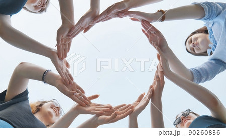 Friends make a circle with their palms against the blue sky. Friends make a circle with their palms against the blue sky. 90260836