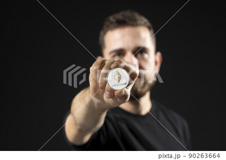 Young attractive successful bearded holding virtual currency ethereum coin. Cryptocurrency. Young attractive successful bearded holding virtual currency ethereum coin. Cryptocurrency. 90263664