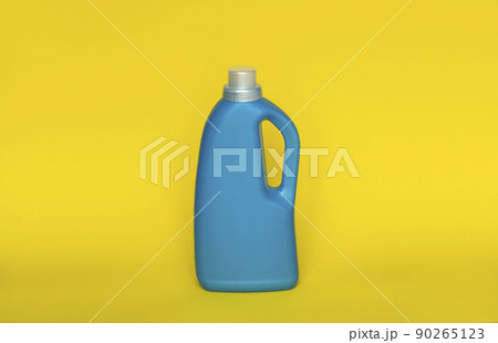 Softener in blue plastic bottle isolated on yellow background. Bottle with liquid laundry detergent, cleaning agent, bleach or fabric softener. Product design. Mock up. 90265123