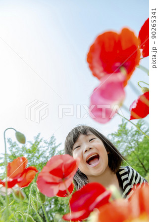 新緑の公園で花を見る女の子 90265341