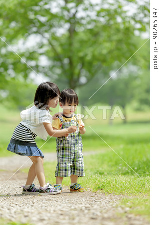 新緑の公園で遊ぶ姉と弟 90265347