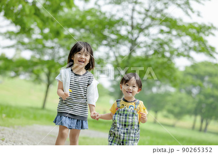 新緑の公園で遊ぶ姉と弟 90265352