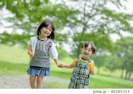新緑の公園で遊ぶ姉と弟 90265353