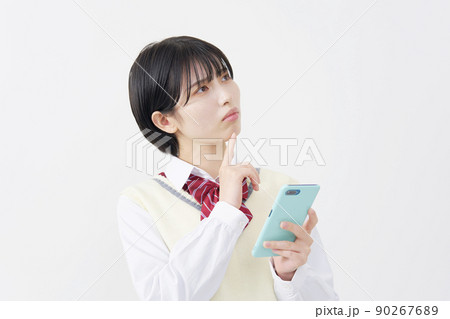 白背景でスマホを持って考える女子高生 白背景でスマホを持って考える女子高生 90267689