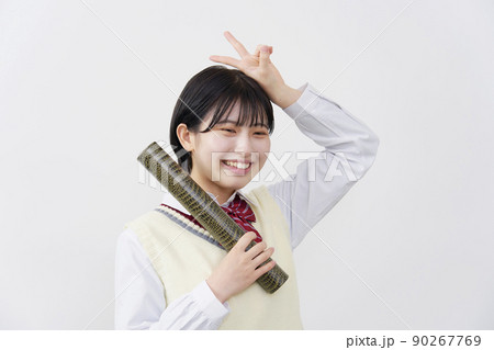 白背景で卒業証書の筒を持ってピースサインする女子高生 90267769