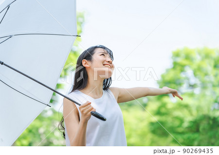 梅雨に傘を持ったアジア人女性(雨上がり・笑顔) 90269435