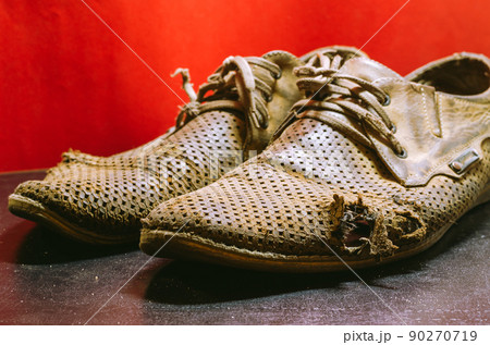 A pair of old yellow leather shoes. Dented men's summer shoes. Close-up. Selective focus. 90270719