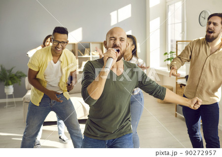 Smiling friends have fun sing karaoke 90272957