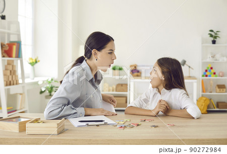 Kid and speech therapist doing articulation exercise to fix some pronunciation problems 90272984