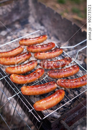 Tasty Sausages grilling on charcoal grill grate 90273521