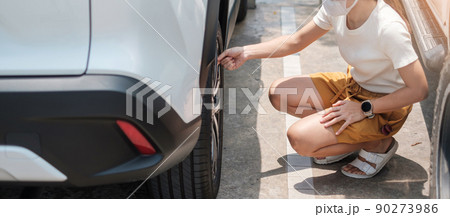 Woman driver hand inflating tires of vehicle, removing tire valve nitrogen cap for checking air pressure and filling air on car wheel at gas station. self service, maintenance and safety 90273986