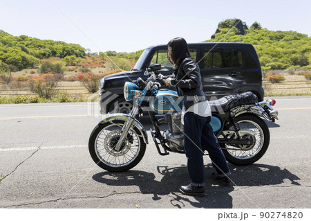 エンストをしたバイクを押す若い女性　エンスト、ガス欠イメージ　 90274820