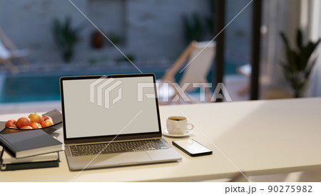 Notebook laptop and copy space on white tabletop house over blurred pool in background. Notebook laptop and copy space on white tabletop house over blurred pool in background. 90275982