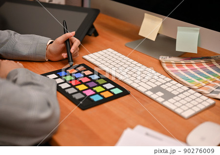 Female freelance graphic designer working at her home office desk. 90276009