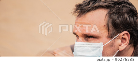 BANNER Close-up side portrait man wear mask, face expression emotion, lies on stomach arms crossed under head. COVID stress syndrome, mental health, fear of danger contamination, social consequence BANNER Close-up side portrait man wear mask, face expression emotion, lies on stomach arms crossed under head. COVID stress syndrome, mental health, fear of danger contamination, social consequence 90276538