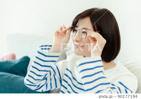 リビングでメガネをかける若い女性 90277194