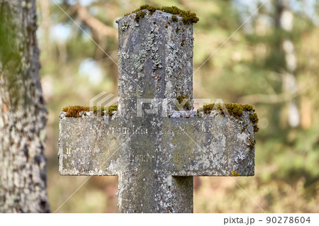 Ancient concrete cross in the cemetery covered by moss. Sunny day. Ancient concrete cross in the cemetery covered by moss. Sunny day. 90278604