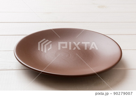 Perspective view of empty plate on wooden background. Empty space for your design 90279007