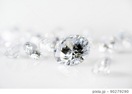 brilliant cut diamond held by tweezers on white background 90279290