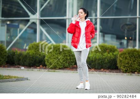 Pretty woman doing fitness outdoors listening to music 90282484