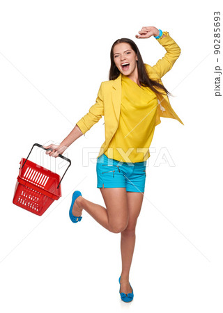 Happy excited woman jumping of joy with empty shopping cart basket, over white background 90285693