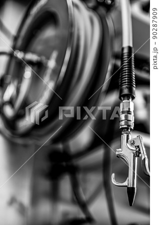 auto-rewinding air hose reel with coiled tubing mounted on a wall in a shop 90287909