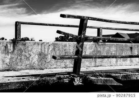 Damaged and bent guardrail along the edge of a bridge that needs repaired. 90287915
