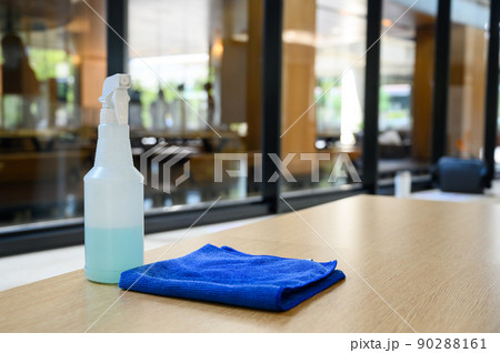 cleaner disinfectant spray bottle with blue microfiber cloth on table. Cleaning products for disinfection. Sanitizer to prevent Coronavirus or Covid-19. Pandemic prevention and control 90288161