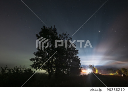 Comet Neowise C2020 F3 as it flies overhead in the summer sky over over meadow near countryside road, Lviv Region, Ukraine. 90288210