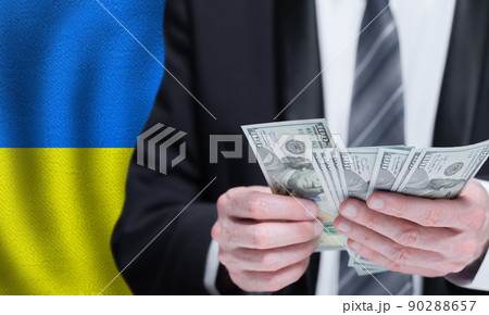 Hands holding dollar money on flag of Ukraine Hands holding dollar money on flag of Ukraine 90288657