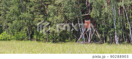 wooden hunting blind on the edge of the forest, near the meadow 90288903