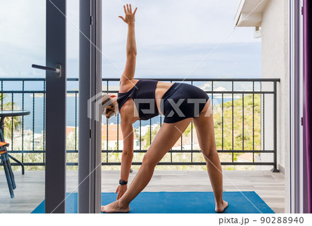 Young woman doing her morning yoga routine at the balcony in the morning 90288940