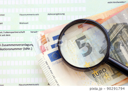 German income tax return form with magnifying glass and european euro money bills lies on accountant table close up. Taxpayers in Germany using euro currency to pay taxes German income tax return form with magnifying glass and european euro money bills lies on accountant table close up. Taxpayers in Germany using euro currency to pay taxes 90291794