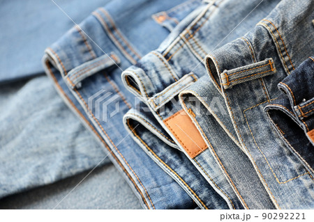 Many jeans in stack in wardrobe room. Row of pants denim jeans in closet. Concept of buy, sell, shopping and fashionable clothes Many jeans in stack in wardrobe room. Row of pants denim jeans in closet. Concept of buy, sell, shopping and fashionable clothes 90292221