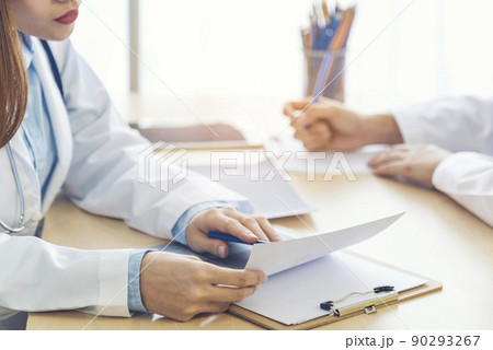 Two asian women hand doctors meeting write prescription medical clinic. Doctor discuss using laptop write note. Close up hands of two women doctor medical lab discussing together healthcare teamwork 90293267