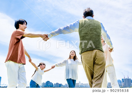公園で輪になって手を繋ぐ家族三世代 90295638